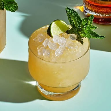 A Mai Tai cocktail garnished with lime and mint.