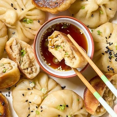 Shengjian bao, pan-fried buns with browned bottoms and sesame seeds.