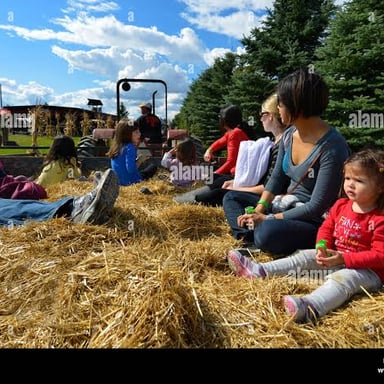 People seated on hay bales during a hayride.