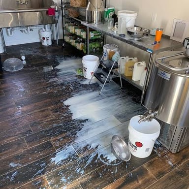 Milk spilled on a kitchen table, the kind of mishap that might prompt an “oopsie.”