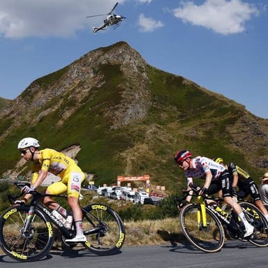 A group of cyclists riding together on a road during a Tour de France stage.