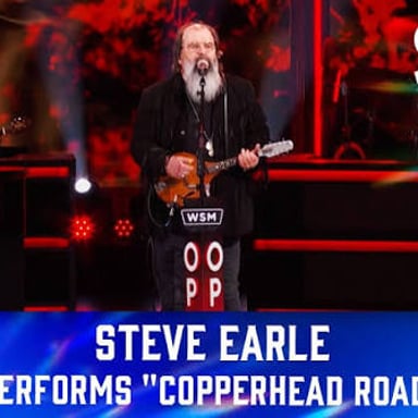 Steve Earle performing with a guitar.