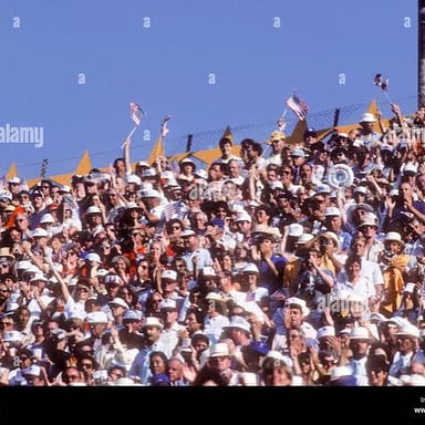 A large crowd cheering loudly at a stadium.