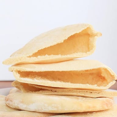A pita flatbread split open to show its pocket.