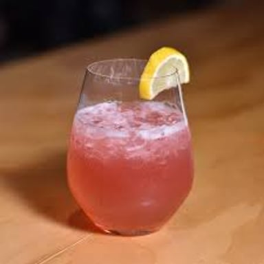 A bubbly sloe gin fizz cocktail served in a glass.