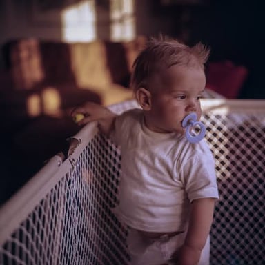 A young child playing safely inside a playpen.