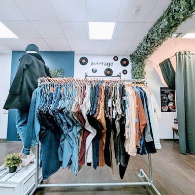 A rack of vintage clothing offered for resale in a secondhand shop.