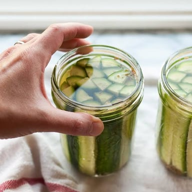 Pickles submerged in brine in a glass jar