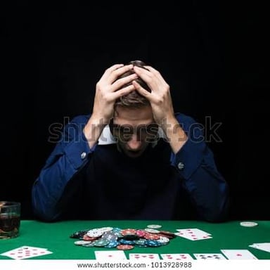 A poker player looking frustrated while seated at a table.