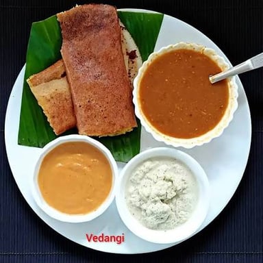 A crisp dosa folded around spiced potato, served with chutney and sambar.