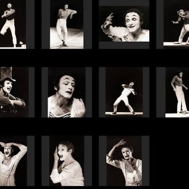 A mime performer uses hand gestures and facial expression to communicate silently.