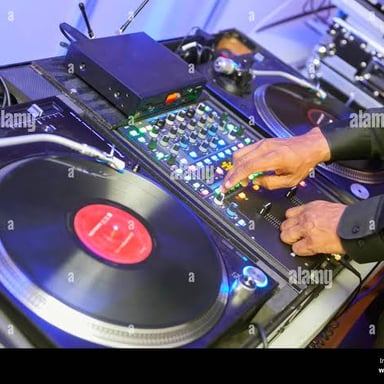 A DJ plays music for a party using turntables and a mixer.