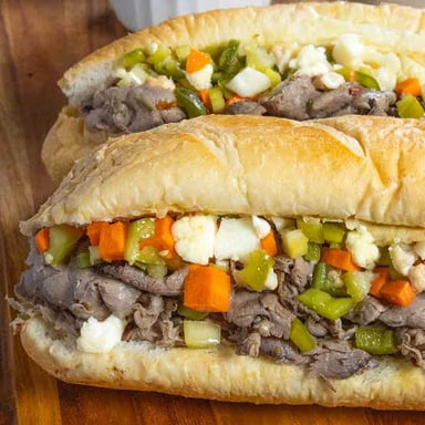 A Chicago-style Italian beef sandwich filled with sliced beef and peppers, with jus for dipping.