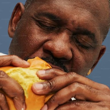 A person eating food quickly and enthusiastically.