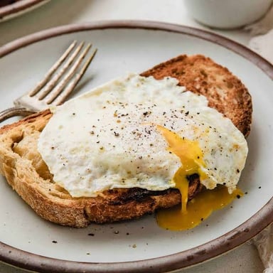Fried eggs cooked over easy, with intact yolks.
