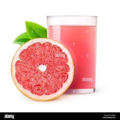 A glass of grapefruit juice beside a cut grapefruit.
